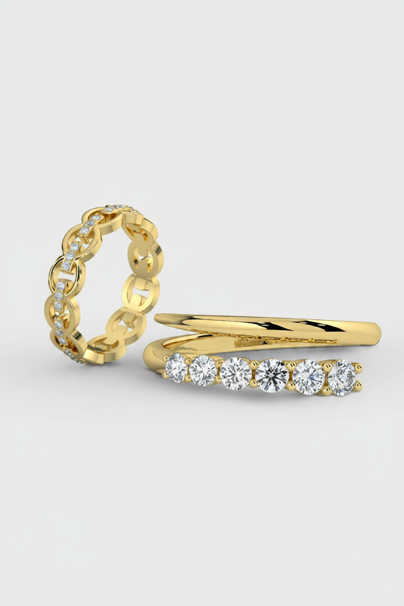 Two yellow gold rings displayed on a light gray background. One ring features a chunky interlocking link design with small clear stones, and the other is a slim band with five round-cut clear stones in a row.